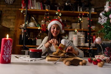 Vegan chef girl cooking sweets in Christmas kitchen next to stuffed cookie doll playing and enjoying