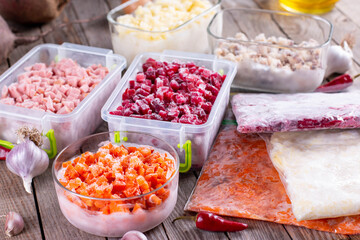 Frozen food in containers and bags on the table. Frozen vegetables