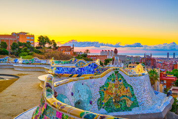 Beautiful sunrise in Barcelona seen from Park Guell. Park was built from 1900 to 1914 and was...