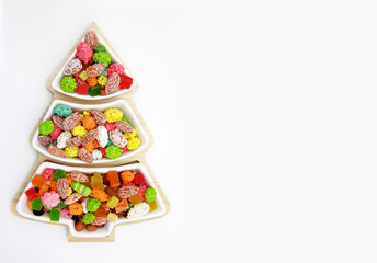 The concept of Oriental sweets for Christmas. A variety of nuts on a plate in the form of a Christmas tree on a white background.Creative idea for a pastry shop. Flatly.The view from the top.Copyspace