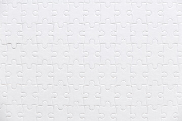 Top view of a white jigsaw puzzle.