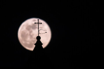 Fototapeta na wymiar Super moon on the steeple of an old church