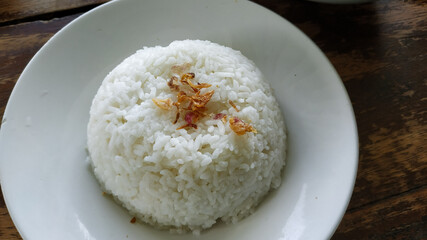 white rice with a sprinkling of fried onions on a white plate