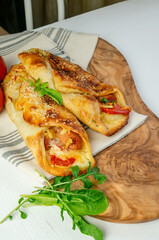 Baked sausage in dough with tomatoes, cheese and herbs mini pizza with sauce and sausage. Homemade cakes, handmade snacks