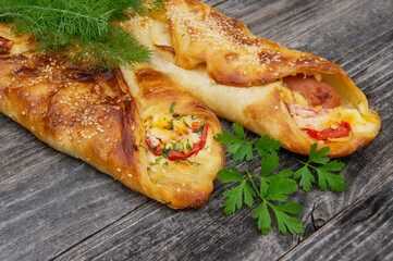 Baked sausage in dough with tomatoes, cheese and herbs mini pizza with sauce and sausage. Homemade cakes, handmade snacks
