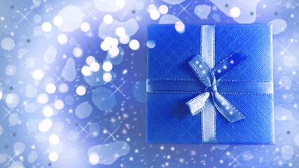 Beautiful box of classic blue color with a bow on a beautiful shiny background. Christmas background with gift box. Copy space. Background