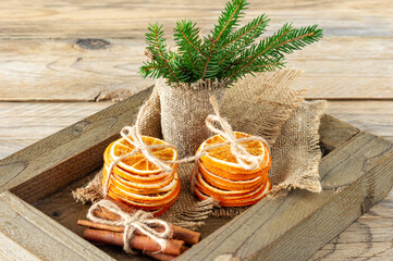 Rustic christmas composition with dried oranges, cinnamon sticks and fir tree branches in a wooden box