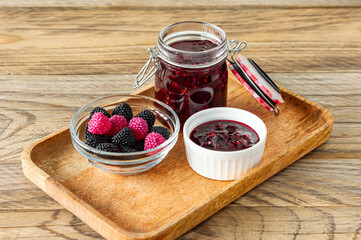 Chewing marmalade jelly candies with berry flavor on wooden table with jam im glass jar.