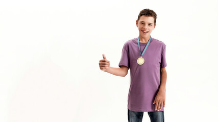 Happy teenaged disabled boy with cerebral palsy wearing gold medal, smiling and showing thumbs up...