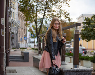 Fototapeta na wymiar Beautiful smiling girl on the street of a modern city, close up