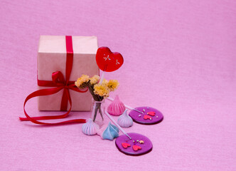 Festive composition. Flat layout. Gift boxes and candies on pink background