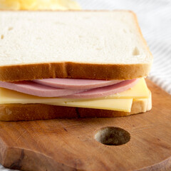 Homemade Bologna and Cheese Sandwich on a rustic wooden board , side view. Close-up. © Liudmyla