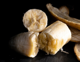 Peeled ripe banana with black background and rolled peel1