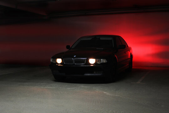 Chernihiv, Ukraine - December 23, 2014: underground parking. BMW 7 (e38) in the shadows with glowing lights in low light
