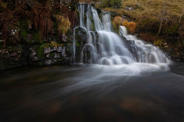 Obraz premium A waterfall from a tributary of The River Tawe not far from its source in the Brecon Beacons, South Wales, UK. 