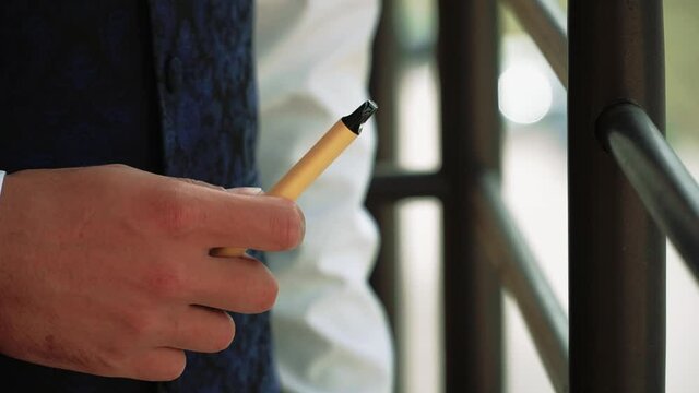 Electronic cigarette in the hands of a man close-up