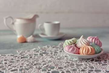 Meringues of a delicate pastel color are on the table for morning tea