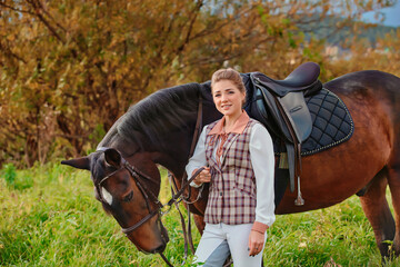 Portrait of a beautiful girl in a classic tracksuit rider with her horse