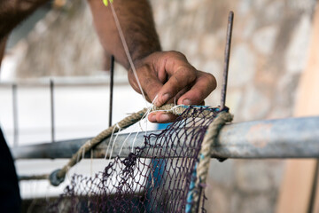 Fisherman repairing fishing nets.