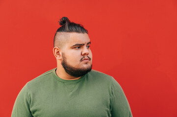 Side view of a puzzled bearded hispanic man with a stylish haircut, frowning, looking seriously...