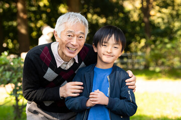 公園ぜおじいちゃんと写真を撮る孫