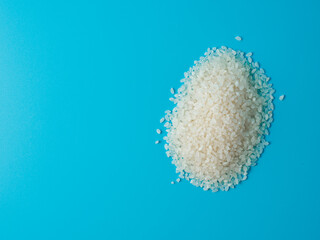 Heap of rice on blue background.