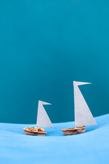 Nut shell sailing ships against blue background.
Segelschiffe aus Nussschale vor blauem Hintergrund.