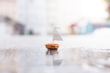 A small boat made of nut shell sailing on street.
Kleines Boot aus Nussschale schwimmt auf der...