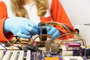 A woman winds electrical tape around the wires.