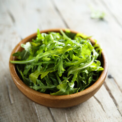 Healthy fresh arugula in a wooden bowl