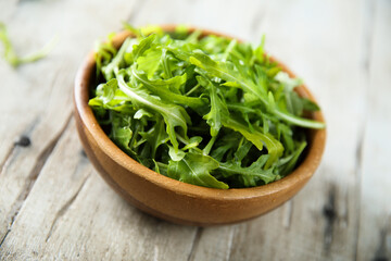 Healthy fresh arugula in a wooden bowl