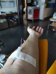Arm with a line drawing blood. Altruistic blood donation. POV of a hospital patient.