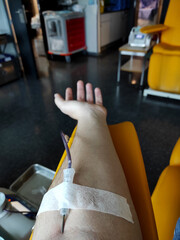 Arm with a line drawing blood. Altruistic blood donation. POV of a hospital patient.