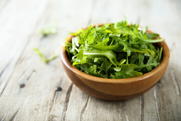 Healthy fresh arugula in a wooden bowl