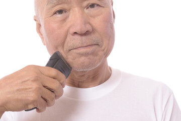 電気シェーバーで髭を剃る日本人シニア男性