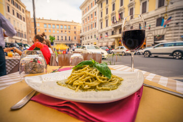 Naklejka na ściany i meble Glass of red wine served with pasta in Rome,Italy