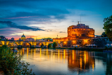 Saint Angelo castle and old bridge with St Peter's basilica in the background near Tiber River in Rome  - obrazy, fototapety, plakaty