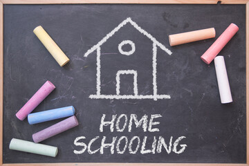 Home Schooling concept on a blackboard with some chalks on it. Alternative education model.