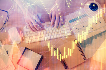 Multi exposure of man's hands typing over computer keyboard and forex graph hologram drawing. Top view. Financial markets concept.