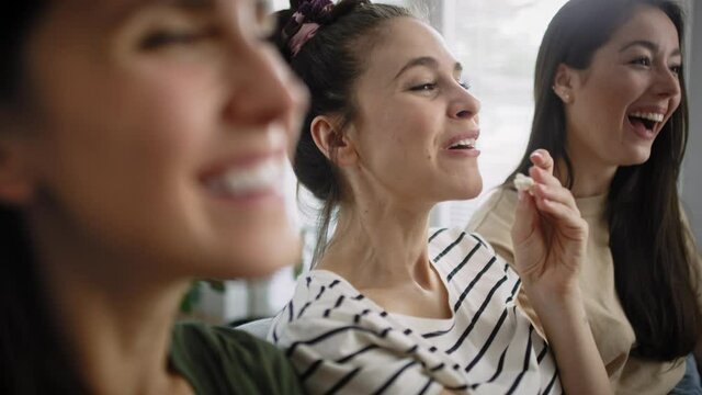Zoom in video of happy women watching TV at home. Shot with RED helium camera in 8K.