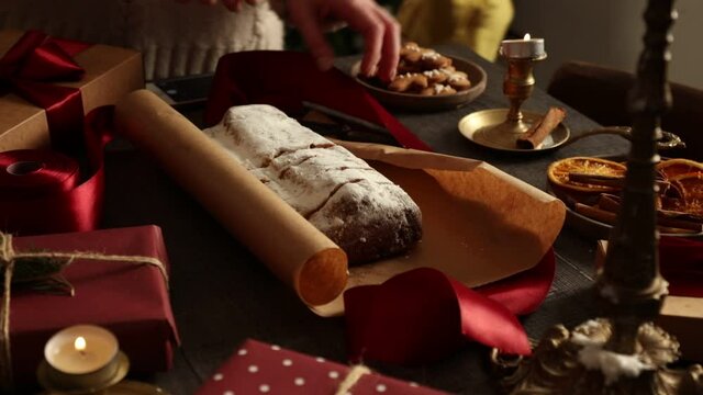 woman wrapping stollen for christmas on a table