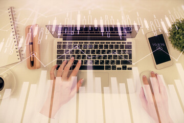 Double exposure of woman hands working on computer and forex chart hologram drawing. Top View. Financial analysis concept.