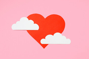 Valentine's Day concept. Red heart in the clouds on a pastel pink background. Greeting card design. Flat lay, top view, copy space