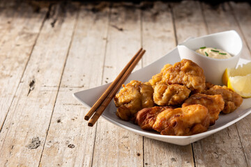Spicy chicken karaage on wooden table. Copy space