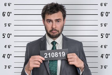 Mugshot of man in suit at police station