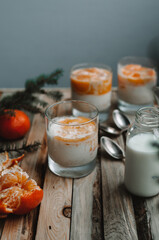 Delicious tangerine cake in glass. Tasty dessert with tangerines, milk, spoon, pineapple and  fir branch. Christmas breakfast concept
