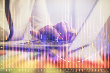 Double exposure of businesswoman hands typing on computer and financial graph hologram drawing. Stock market analysis concept.