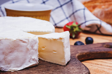 Delicious soft camambert cheese on wooden board