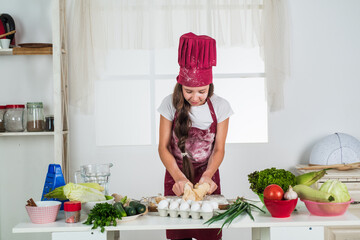 small girl baking in kitchen. kid chef cooking making dough. child prepare healthy food at home and wearing cook uniform. housekeeping and home helping. childhood development. Chef prepares meal