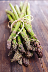 Raw fresh green asparagus on wooden table